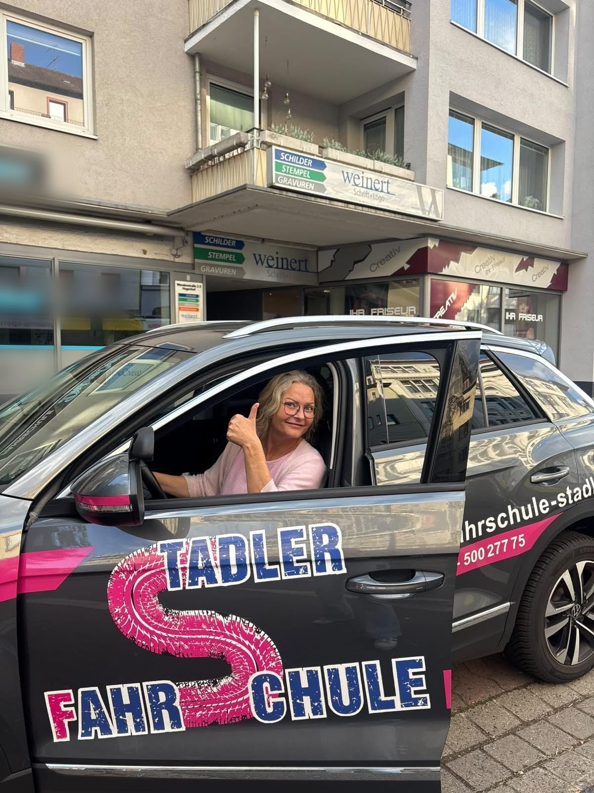 Fahrlehrerin Michaela Stadler im Fahrschulauto vor der Fahrschule am Hagenmarkt in Braunschweig